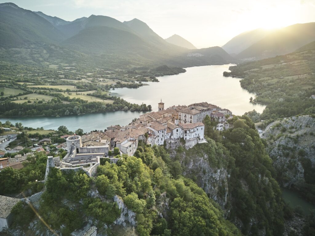 Blick über ein wunderschönes Bergdorf vor einem See in den Bergen Italiens