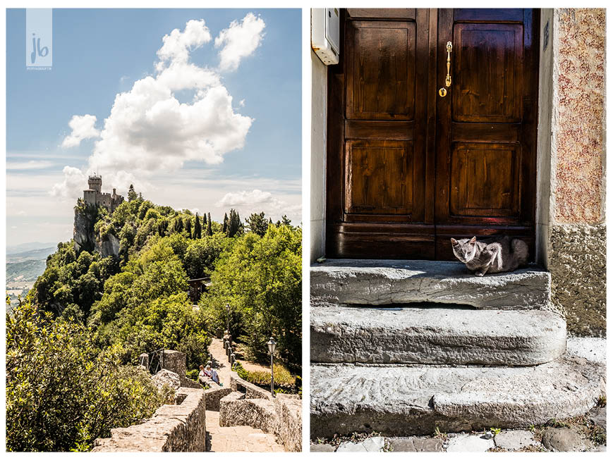 eine graue Katze vor einer braunen Holztür und das Schloss bei San Marino