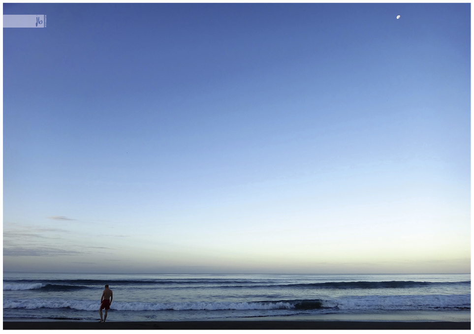 Das Meer bei Sonnenaufgang mit dem Mond am Himmel.