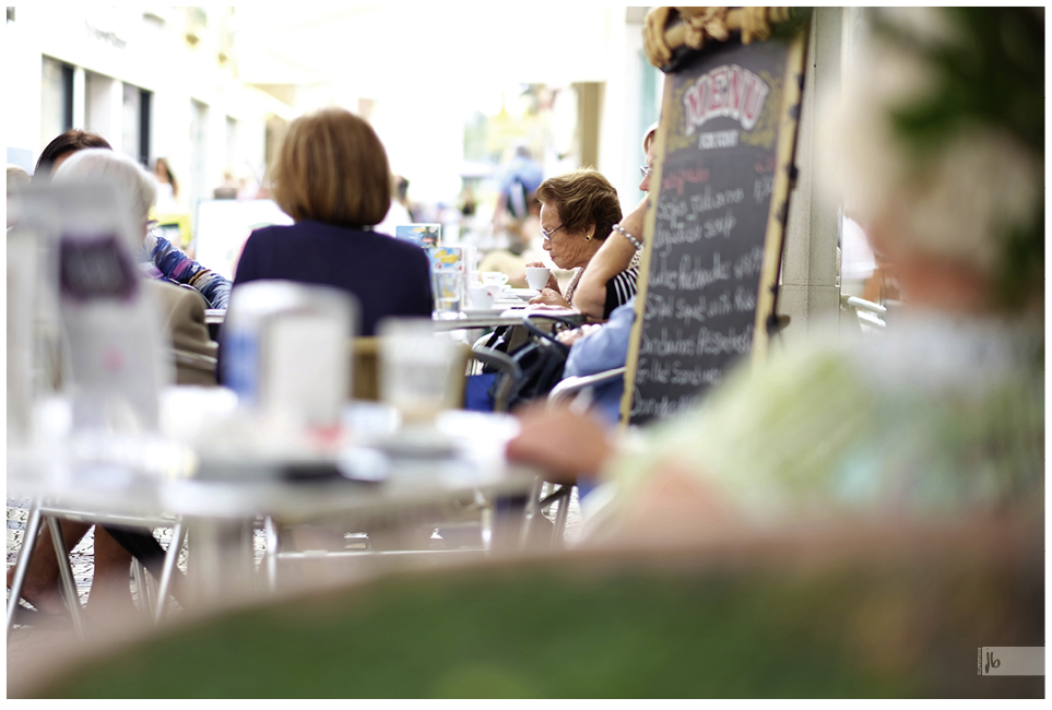 eine alte Dame sitzt in einem Café in Portugal