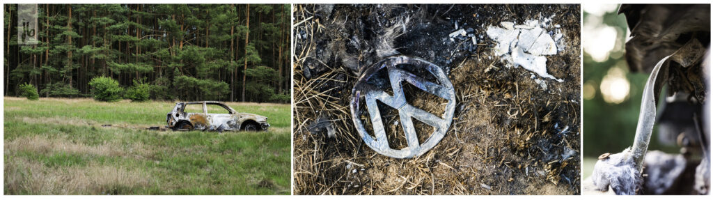 die Spuren eines Brandes an einem VW Auto, das Emblem liegt verkohlt auf dem Boden