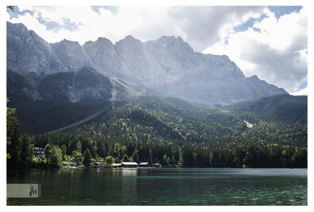 der Eibsee mit seinem türkisblauen Wasser umringt von grauen Felswänden