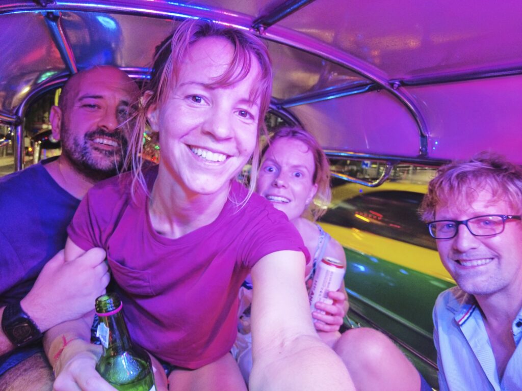 wir sitzen zu viert gezwängt in einem TukTuk und fahren durch Bangkok.