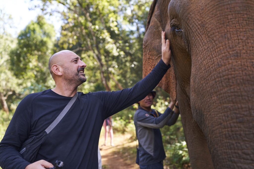 ein Mann (Robert) streichelt eine der beiden Elefanten Damen des Mondulkiri Projects in Senmonorom 