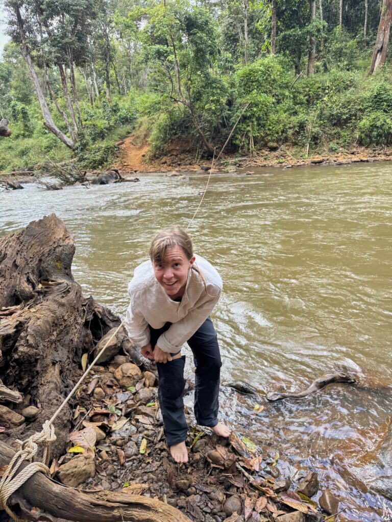 eine Frau (ich) zieht ihre Wanderhose wieder an, nachdem sie im Fluss mit den Elefanten gebadet hat