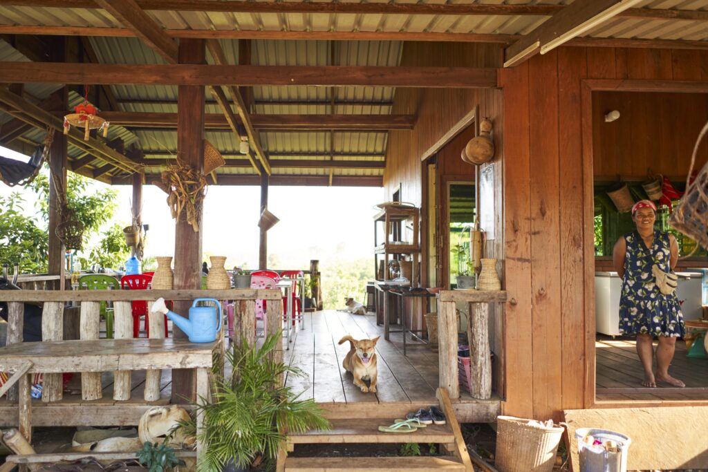 ein Hund sitzt vor dem Zugang zu einem Café mit Ausblick