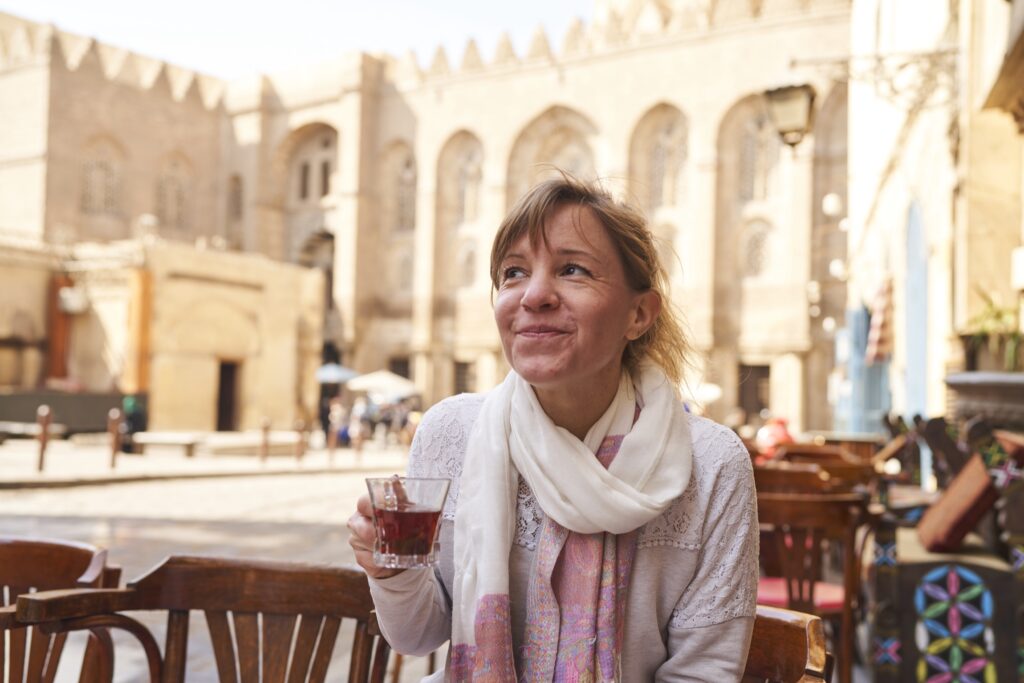 Ich trinke ein Glas Tee in Kairo in einem Cafe, hinter mir eine schöne Fassade