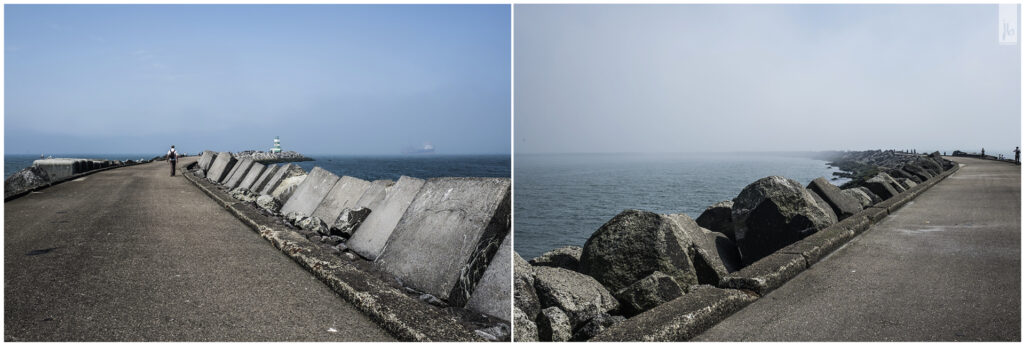 ein langer Betonsteg zu einem Leuchtturm