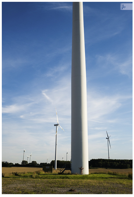 Windräder in der Landschaft, die jemand umarmt