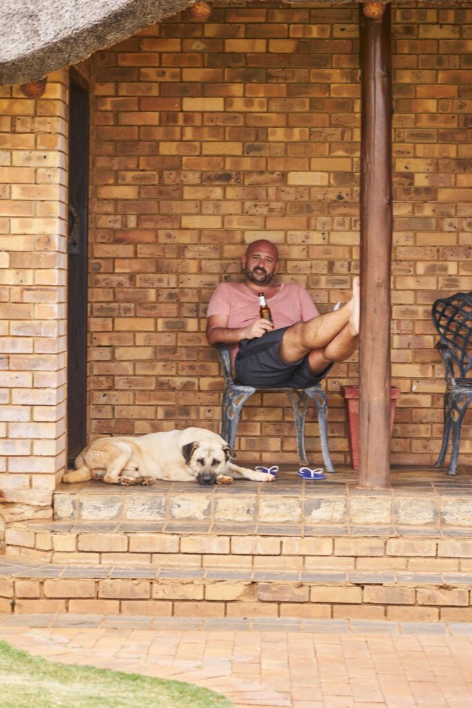 der Hund gesellt sich zu Robert auf die Terrasse unserer Lodge in der Morakane Safari Lodge, Kalahari, Südafrika